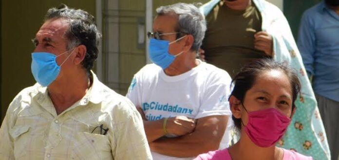 Gente en vía pública con cubrebocas