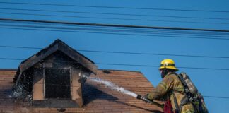 Abuelita y su nieto lograron salir a tiempo mientras su casa se incendiaba. Bombero apagando incendio